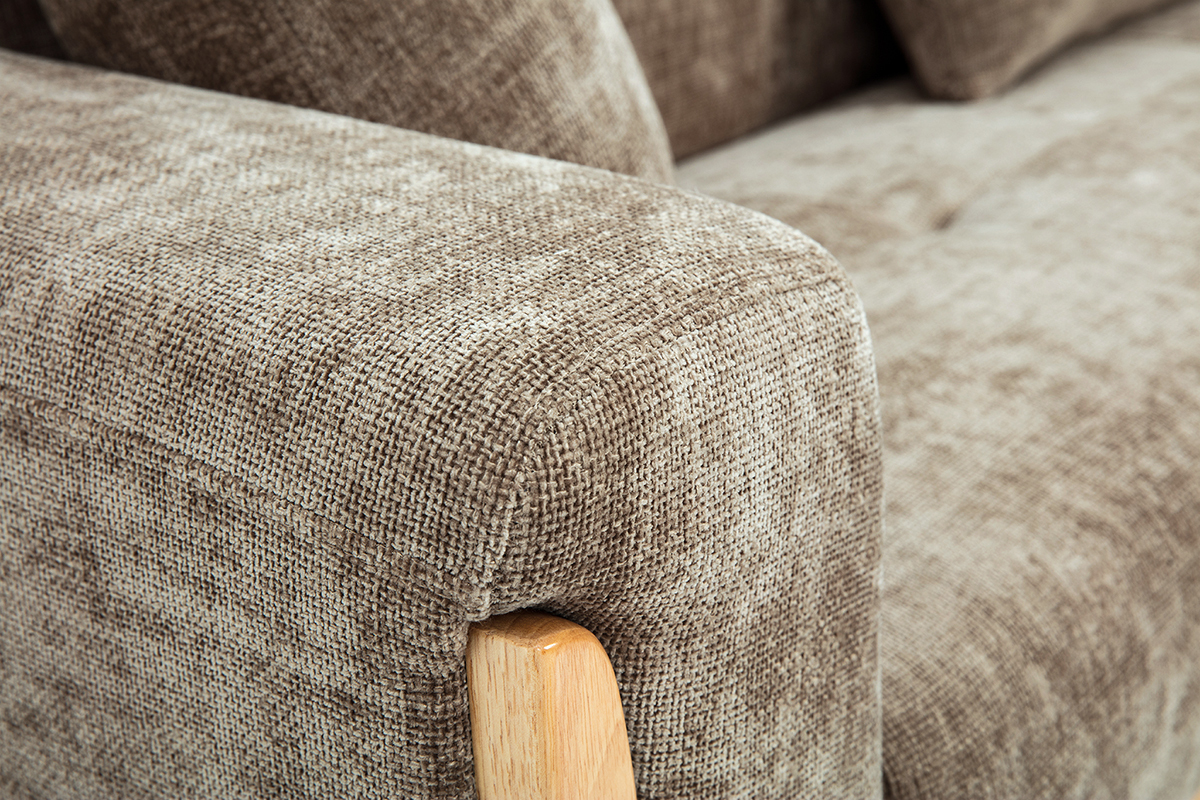 Gros plan sur l'accoudoir du canap� scandinave effet velours taupe et bois clair.