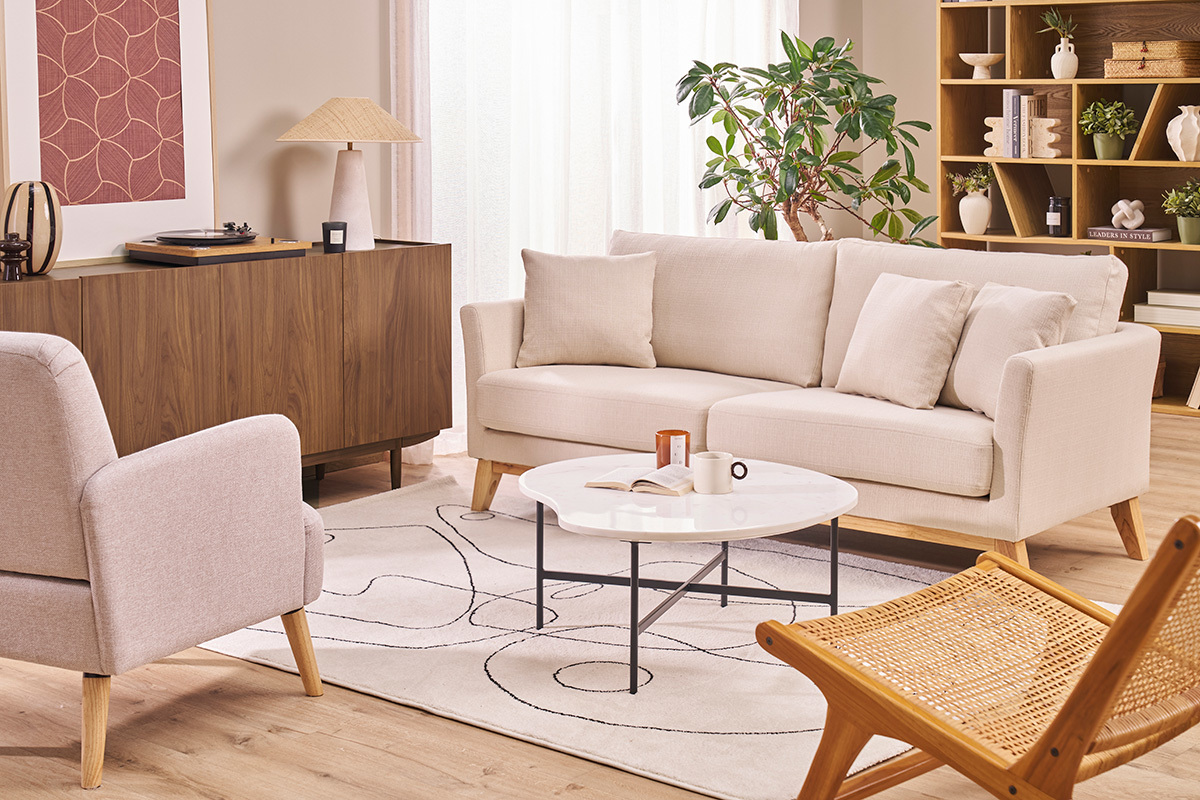Canap� scandinave 3 places beige, pieds en bois clair, avec coussins dans salon moderne.