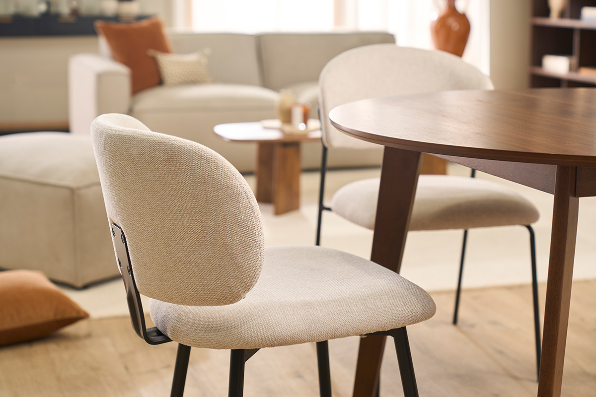 Chaises ATRIUM en tissu beige et m�tal noir autour d'une table en bois.