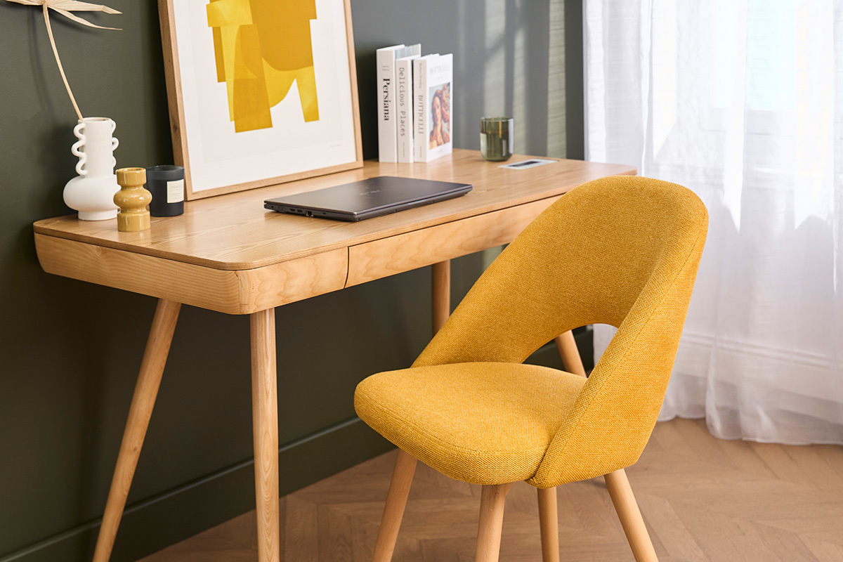 Chaise scandinave en tissu jaune moutarde pr�s d'un bureau en bois clair.