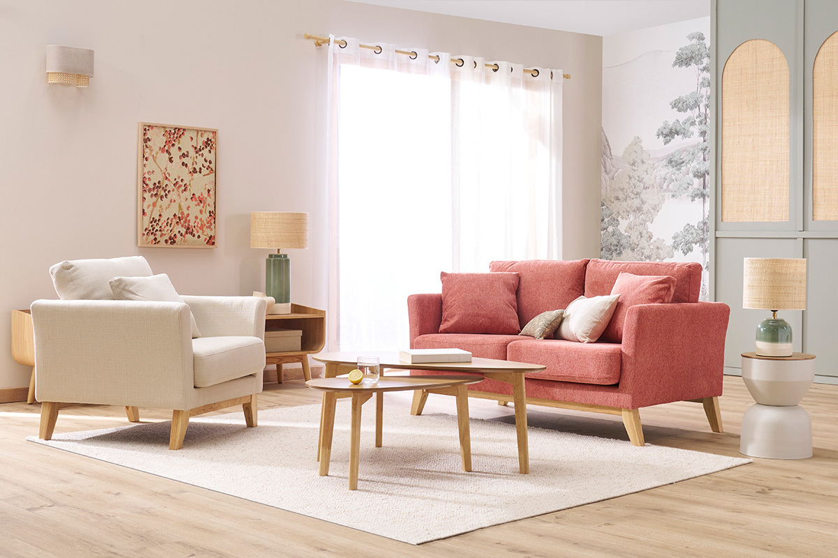 Fauteuil scandinave d�houssable beige en tissu et bois clair, vue dans un salon lumineux avec canap� corail.