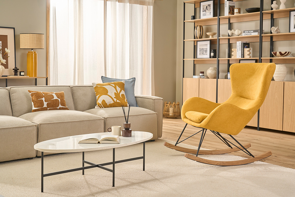 Rocking chair scandinave en tissu velours jaune moutarde dans une salle de s�jour moderne avec canap� et table basse.