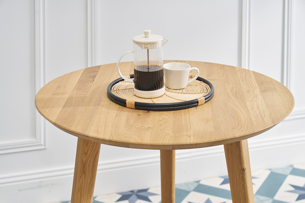 Table � manger ronde en bois ch�ne avec cafeti�re et tasse, vue de dessus.