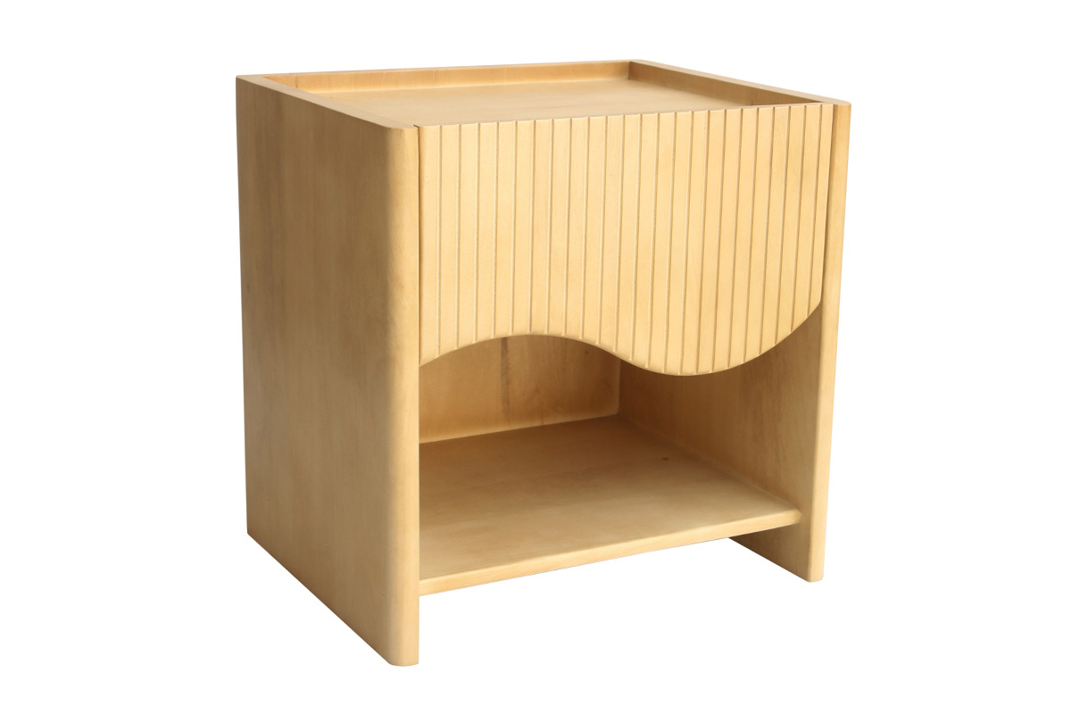 Table de chevet en bois de manguier avec tiroir sculpt� ondul� et niche ouverte, vue de trois quarts.